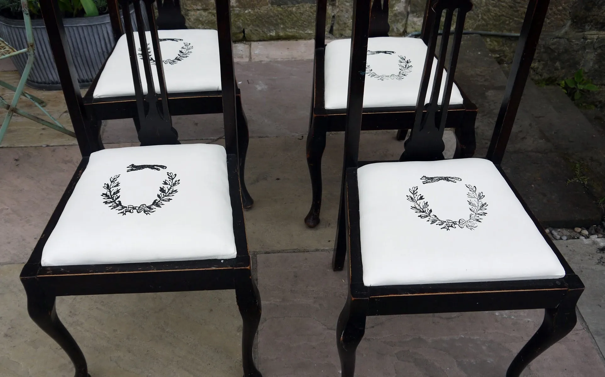 Set of four wooden vintage dining chairs with updated seat pads with a fox and wreath design.